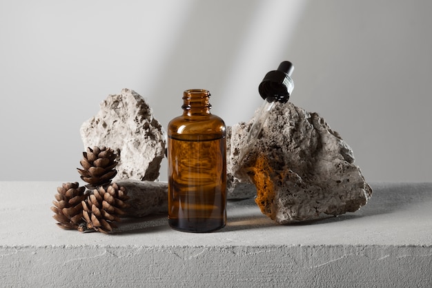 Amber glass bottles and botanical extracts arranged on a plain ground