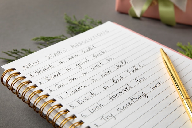An open notebook with handwritten formulation notes beside dried botanicals